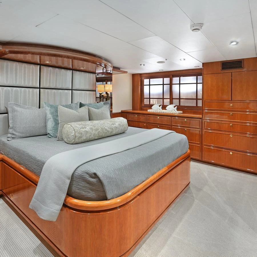 The master stateroom features a luxurious bed with elegant wood paneling and ample storage space. aboard MILES AWEIGH Yacht for Sale