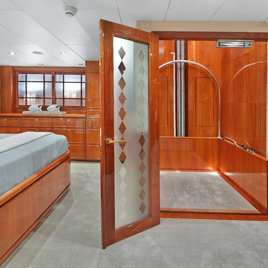 The luxurious stateroom features elegant wood paneling and a spacious ensuite bathroom. aboard MILES AWEIGH Yacht for Sale