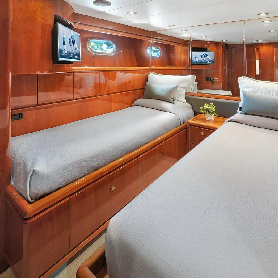 The twin stateroom features elegant wood paneling and modern amenities for a comfortable stay. aboard MILES AWEIGH Yacht for Sale