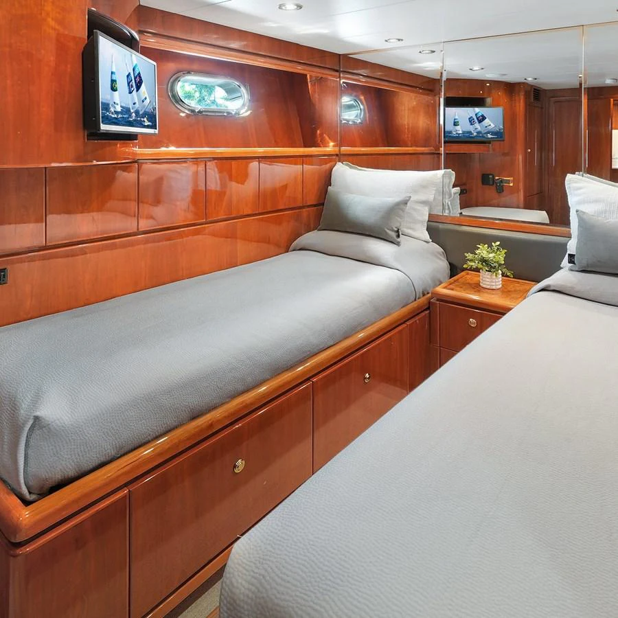 The guest stateroom features twin beds, polished wood finishes, and modern amenities for a comfortable stay. aboard MILES AWEIGH Yacht for Sale