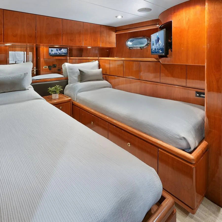 A cozy twin stateroom featuring polished wood paneling and modern amenities. aboard MILES AWEIGH Yacht for Sale