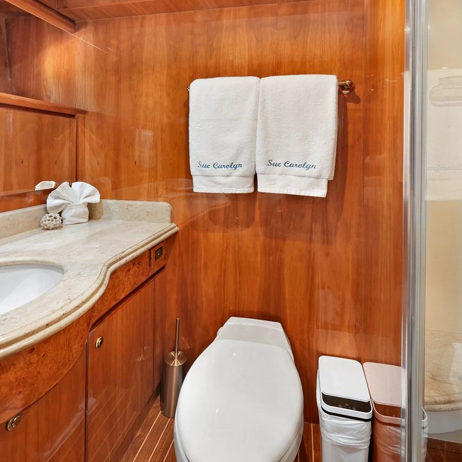 A luxurious yacht bathroom featuring elegant wood paneling and modern amenities. aboard MILES AWEIGH Yacht for Sale