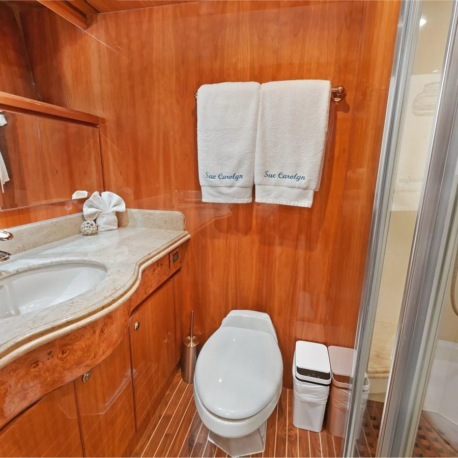 The yacht's bathroom features elegant wood paneling and a sleek modern design. aboard MILES AWEIGH Yacht for Sale
