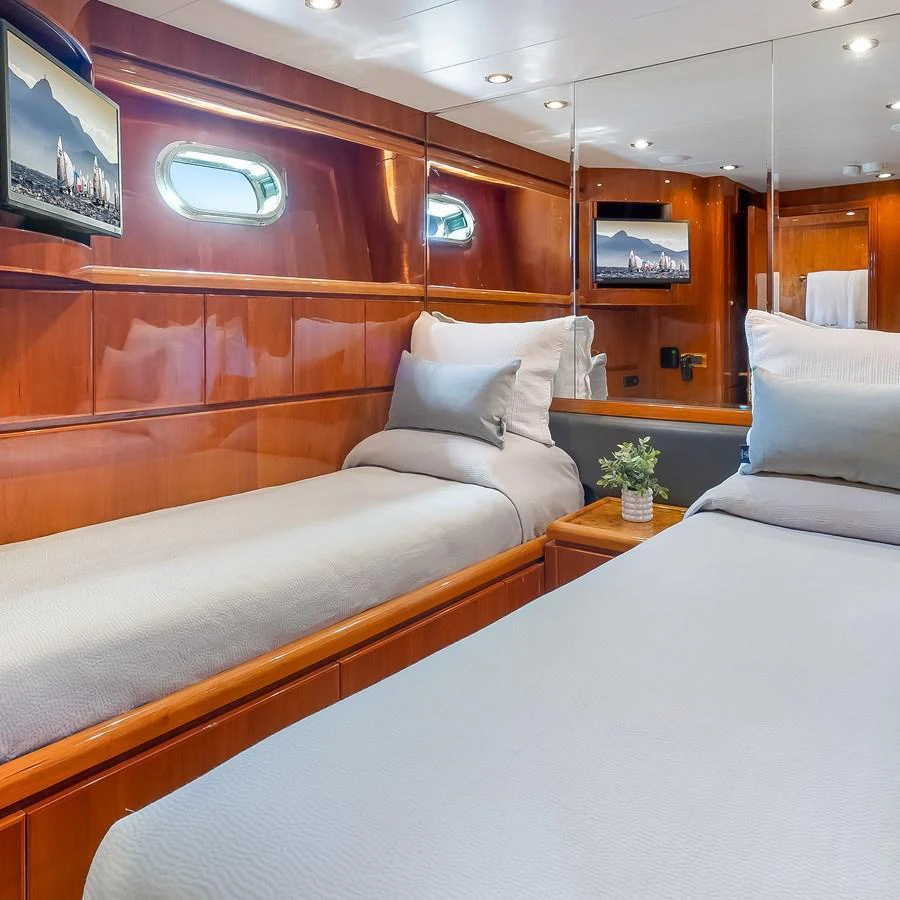 The guest stateroom features twin beds with luxurious bedding and warm wood finishes. aboard MILES AWEIGH Yacht for Sale