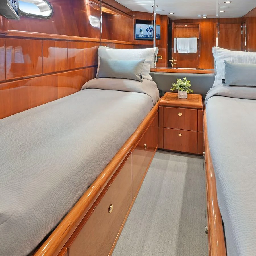 The twin stateroom features polished wood paneling and comfortable twin beds with neutral bedding. aboard MILES AWEIGH Yacht for Sale