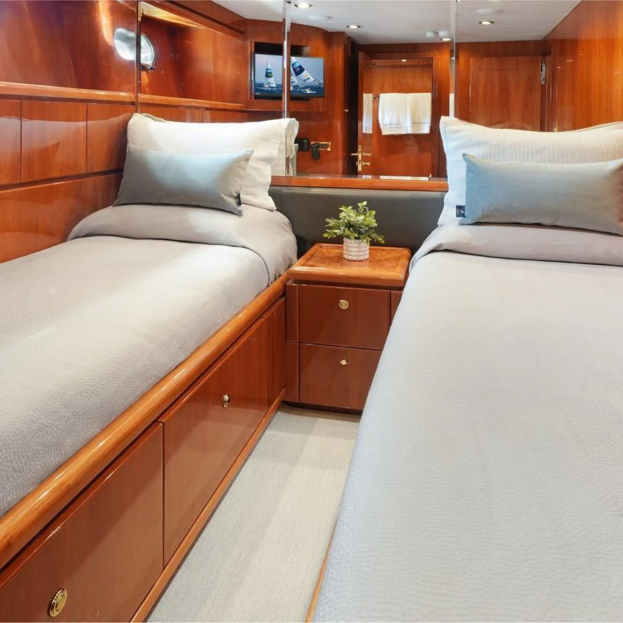 The twin stateroom features elegant wood paneling and comfortable bedding. aboard MILES AWEIGH Yacht for Sale