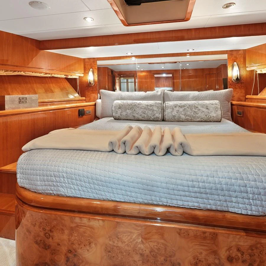 The master stateroom features luxurious wood paneling and a plush bed with elegant bedding. aboard MILES AWEIGH Yacht for Sale