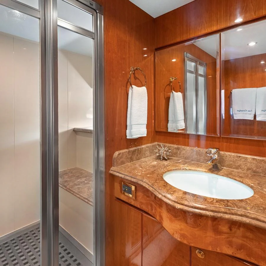 The yacht's bathroom features elegant wood finishes and a marble countertop. aboard MILES AWEIGH Yacht for Sale