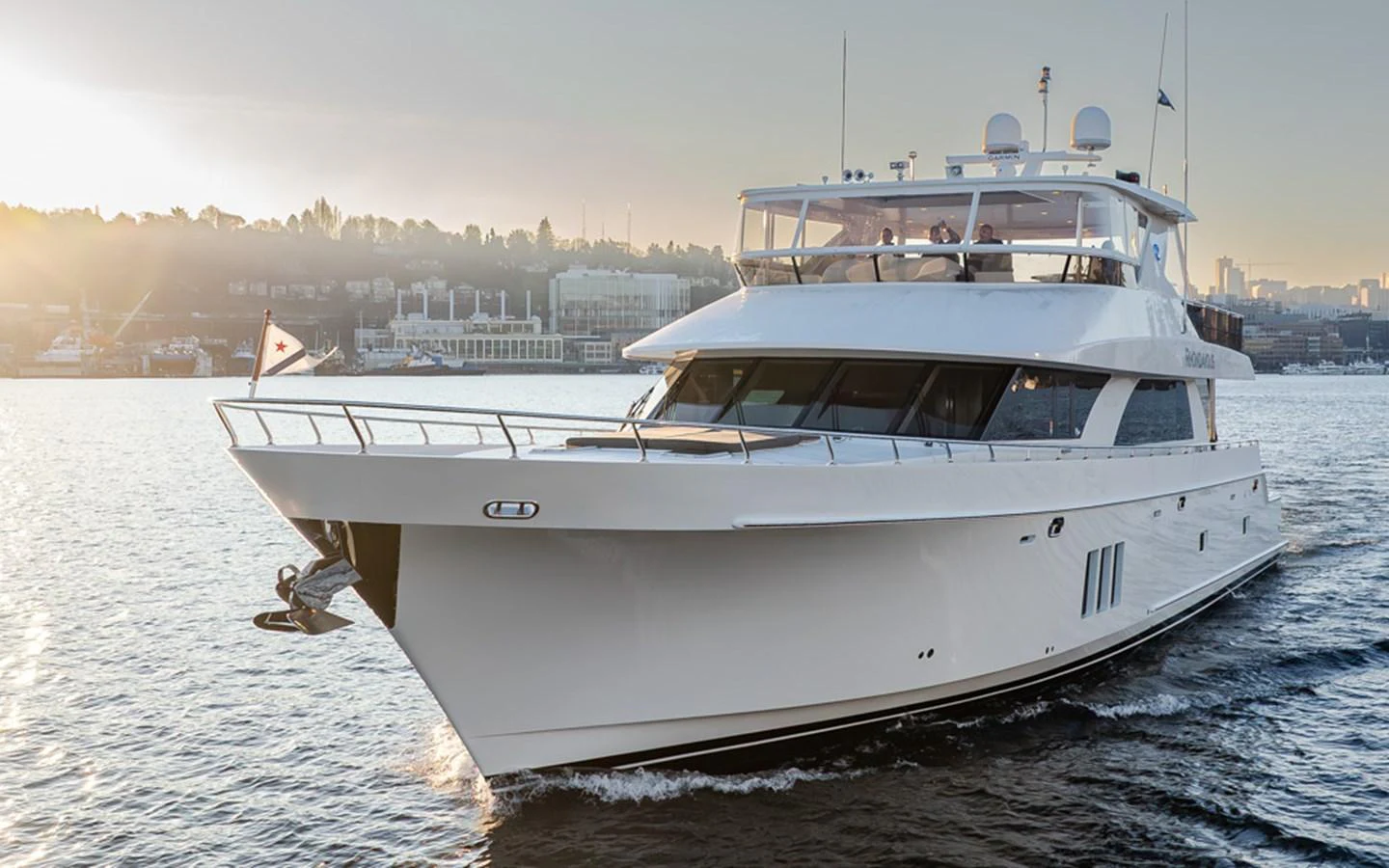 A sleek and modern yacht glides through the water at sunset, showcasing its elegant design and spacious deck. aboard RHONDAVOUS Yacht for Sale