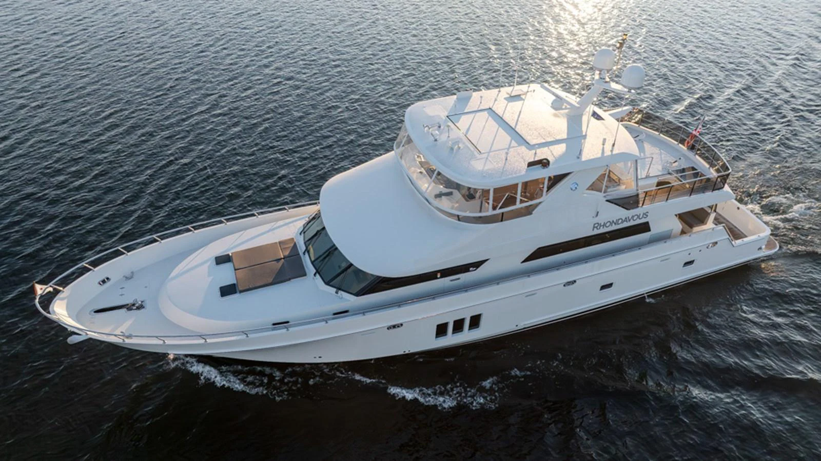A sleek and modern yacht glides gracefully on the water, showcasing its elegant design and spacious decks. aboard RHONDAVOUS Yacht for Sale