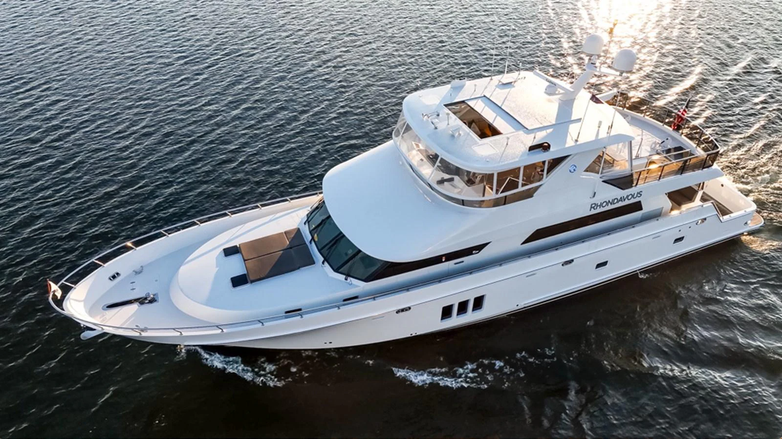 A sleek and modern yacht glides gracefully through the water, showcasing its elegant design and spacious decks. aboard RHONDAVOUS Yacht for Sale
