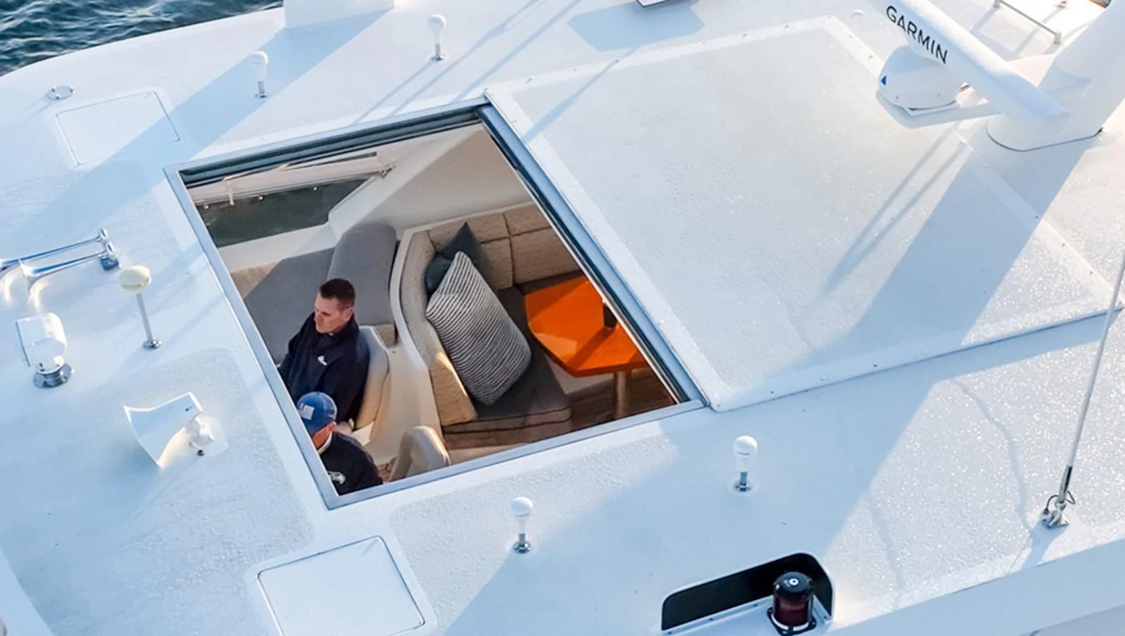 A view from above showing a partially open sunroof revealing a cozy seating area inside the yacht. aboard RHONDAVOUS Yacht for Sale