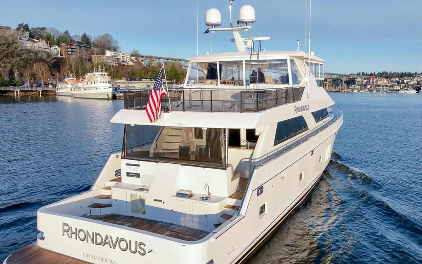 The yacht is cruising on calm waters, showcasing its spacious aft deck and sleek design. aboard RHONDAVOUS Yacht for Sale