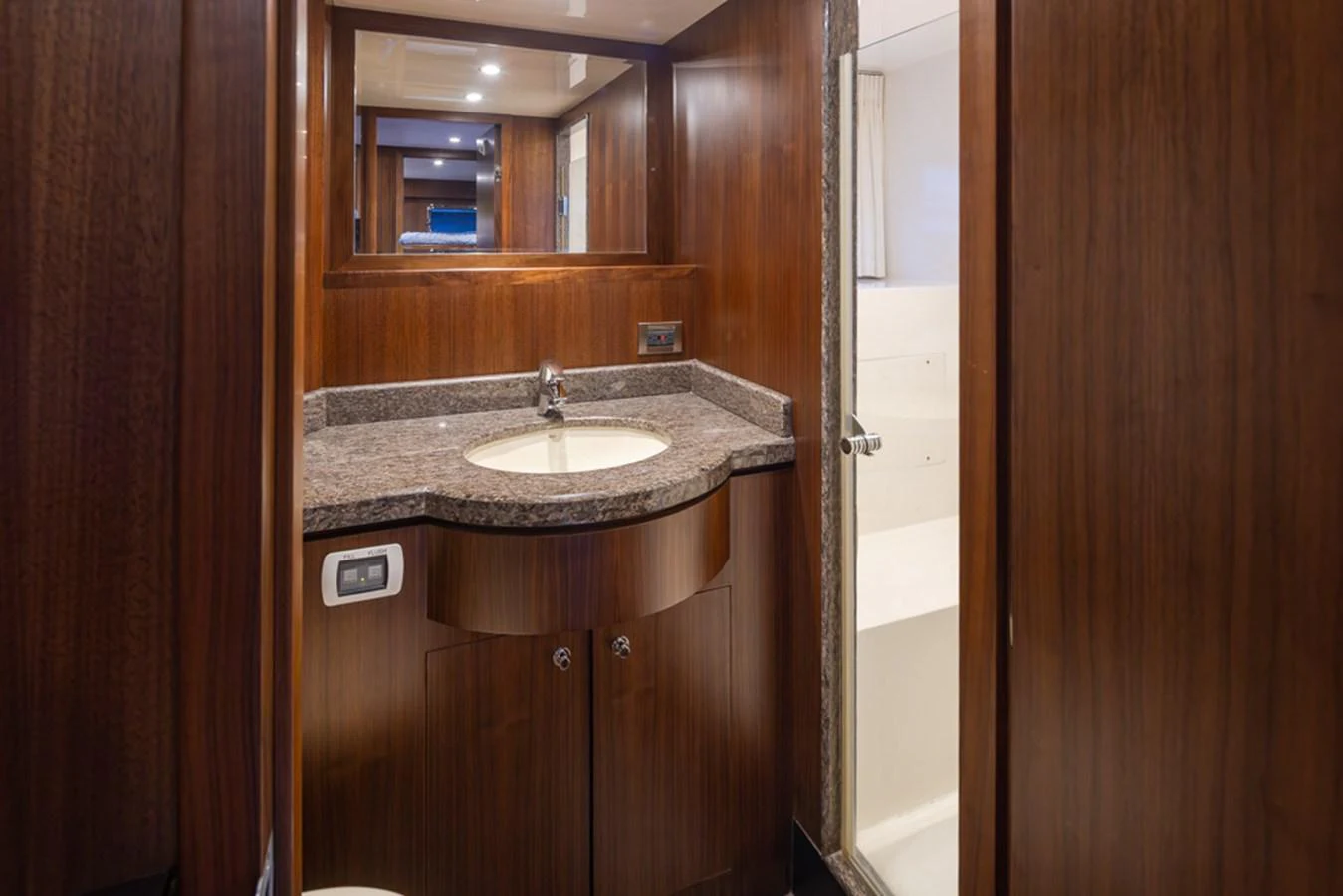 The yacht's bathroom features elegant wood paneling and a sleek countertop with a modern sink. aboard RHONDAVOUS Yacht for Sale