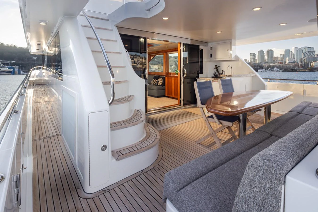 The aft deck features a comfortable seating area with a dining table and easy access to the interior. aboard RHONDAVOUS Yacht for Sale
