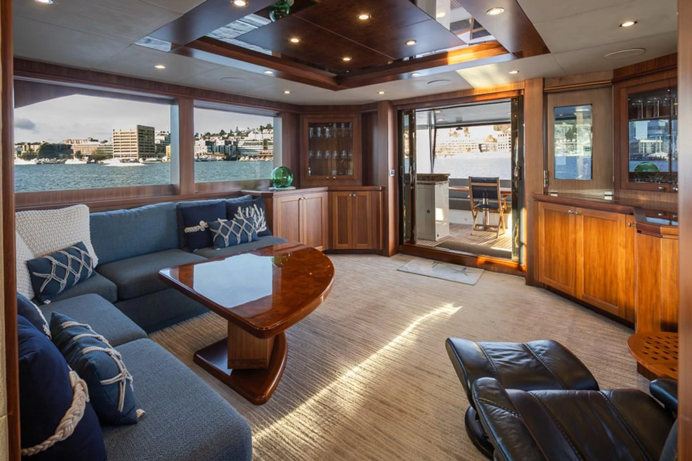 The salon offers a spacious and elegant area with comfortable seating and beautiful wood finishes, perfect for relaxation and socializing. aboard RHONDAVOUS Yacht for Sale