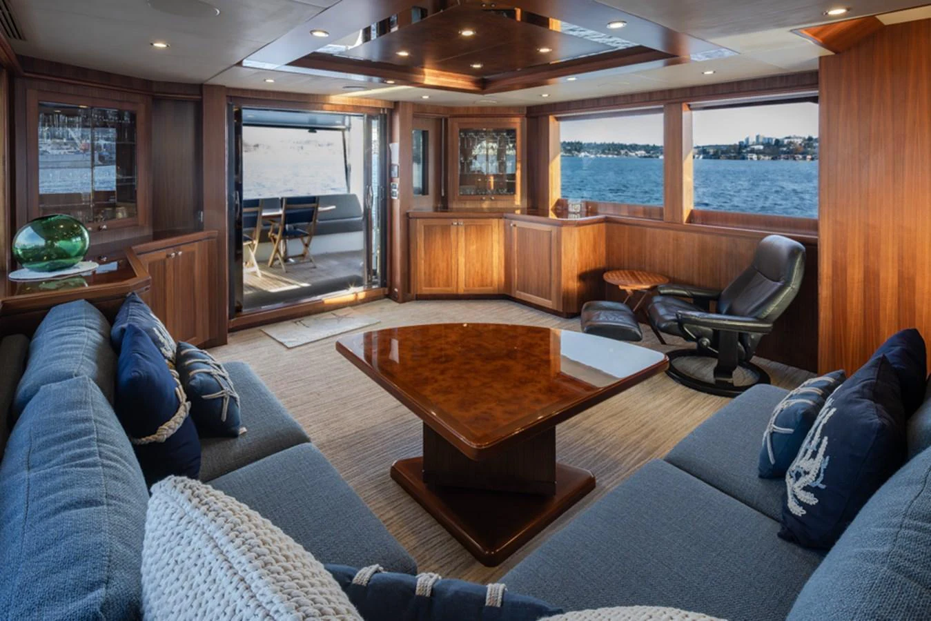 The yacht's salon features plush seating, a polished wooden table, and expansive windows offering stunning sea views. aboard RHONDAVOUS Yacht for Sale