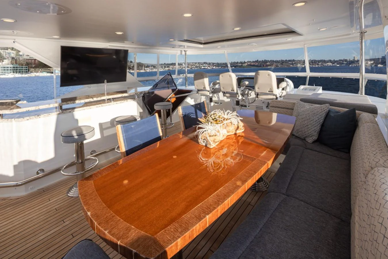 The flybridge offers a spacious and luxurious seating area with a polished wooden table and panoramic views. aboard RHONDAVOUS Yacht for Sale