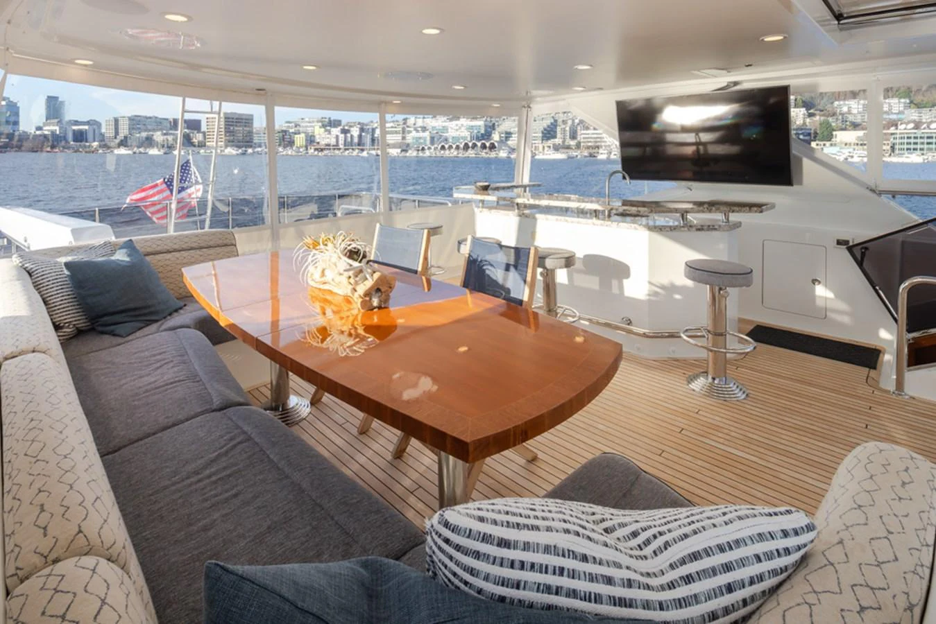 The aft deck features a spacious seating area with a polished wooden table, perfect for enjoying the view. aboard RHONDAVOUS Yacht for Sale