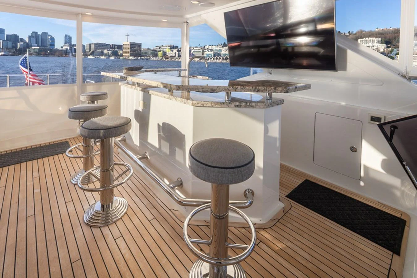 The flybridge offers a stylish bar area with a stunning view of the city skyline. aboard RHONDAVOUS Yacht for Sale