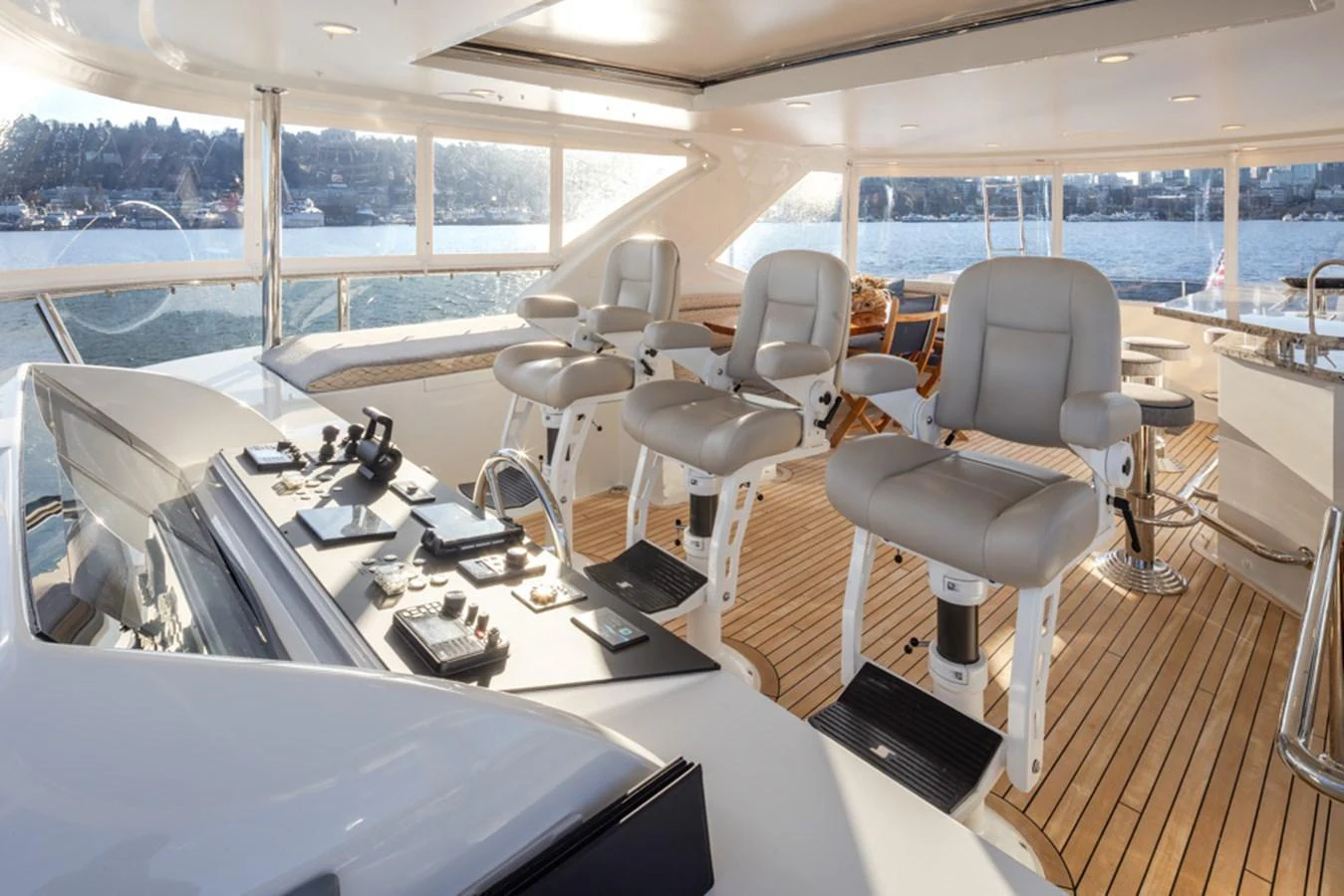 The helm area features multiple comfortable captain's chairs with a panoramic view of the water. aboard RHONDAVOUS Yacht for Sale
