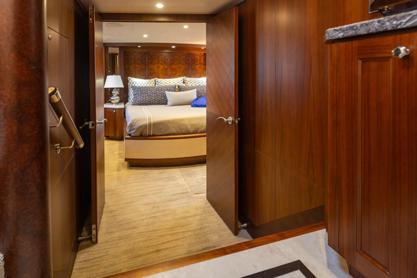 A luxurious stateroom with rich wood paneling and a plush bed invites relaxation. aboard RHONDAVOUS Yacht for Sale