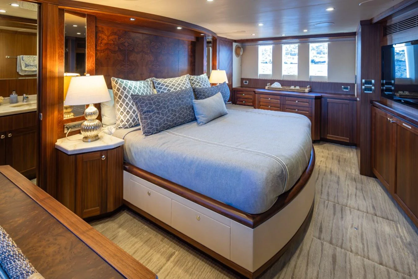 The master stateroom features a spacious bed with elegant wood finishes and ample natural light. aboard RHONDAVOUS Yacht for Sale