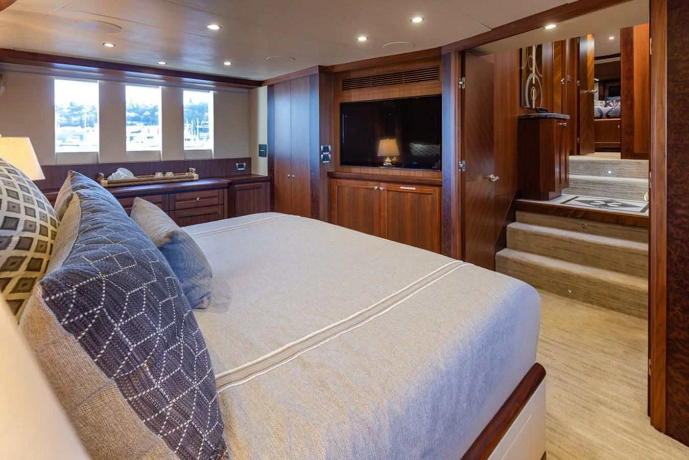The master stateroom features a luxurious bed with elegant bedding and warm wood finishes. aboard RHONDAVOUS Yacht for Sale