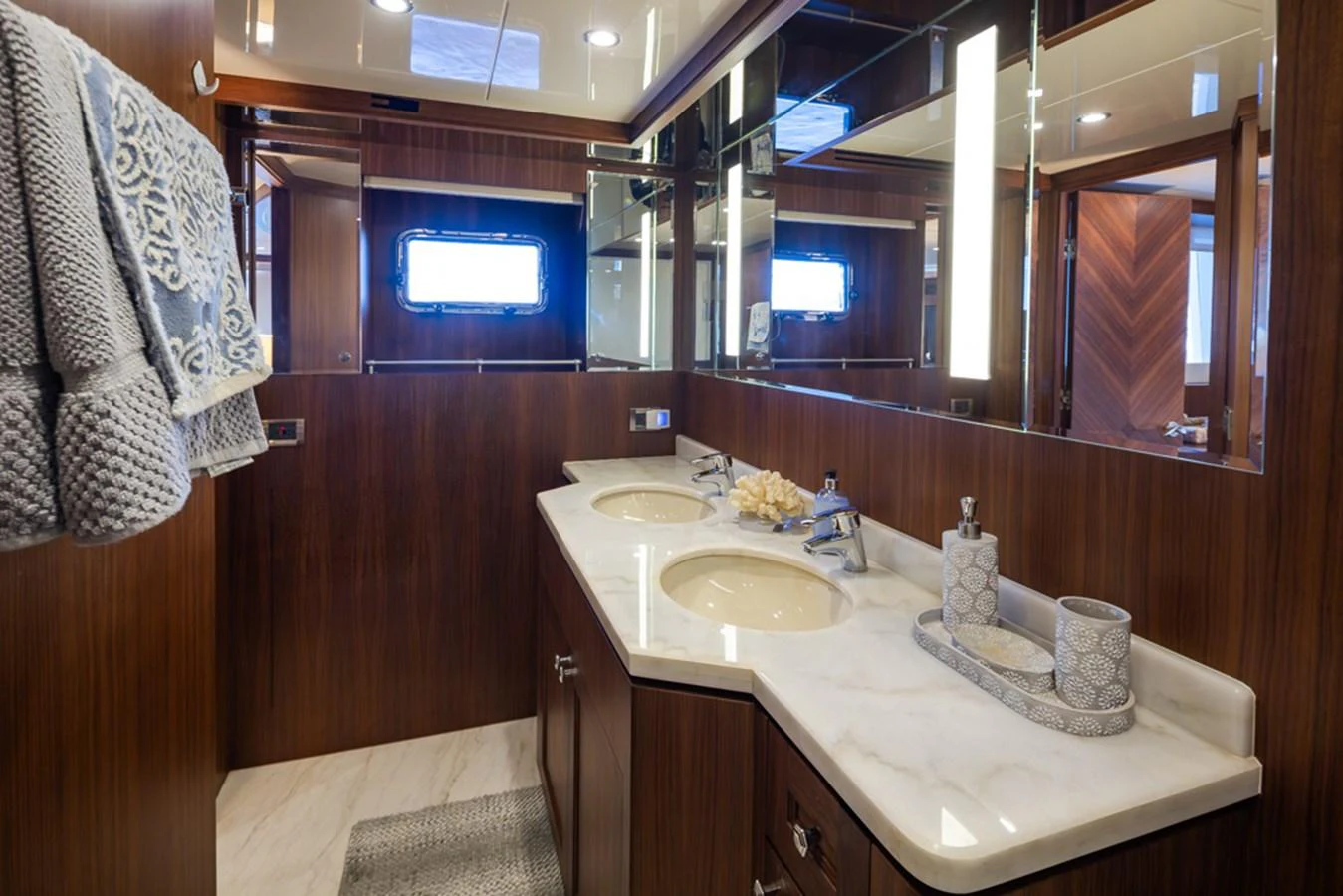The yacht's bathroom features elegant wood paneling and a double sink vanity with luxurious fixtures. aboard RHONDAVOUS Yacht for Sale
