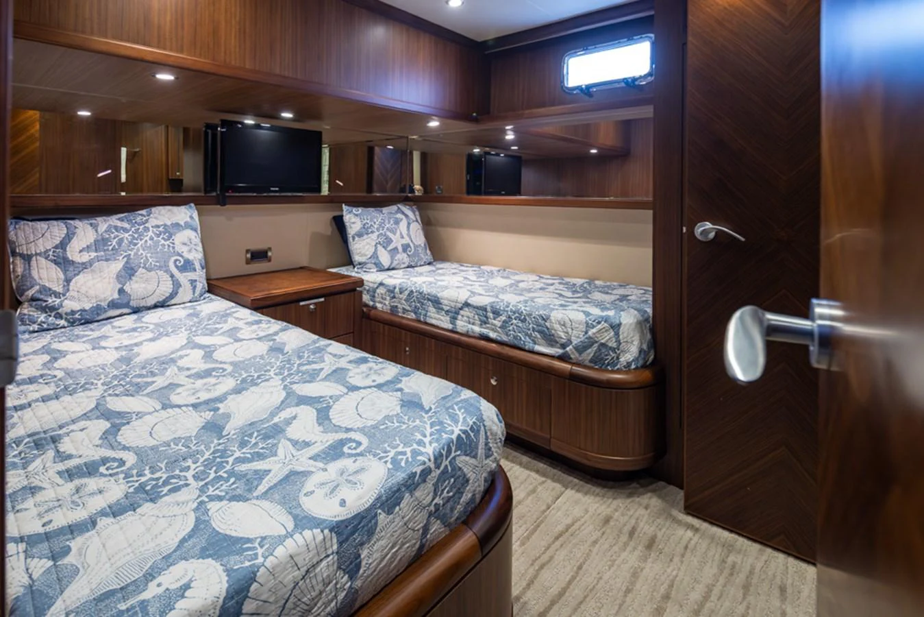 The twin stateroom features two comfortable beds with nautical-themed bedding and elegant wood paneling. aboard RHONDAVOUS Yacht for Sale