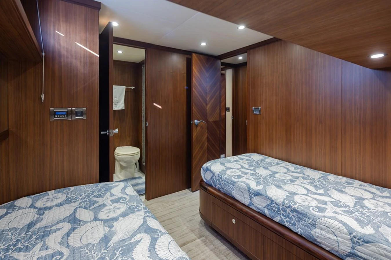 The guest cabin features twin beds with nautical-themed bedding and an en-suite bathroom. aboard RHONDAVOUS Yacht for Sale