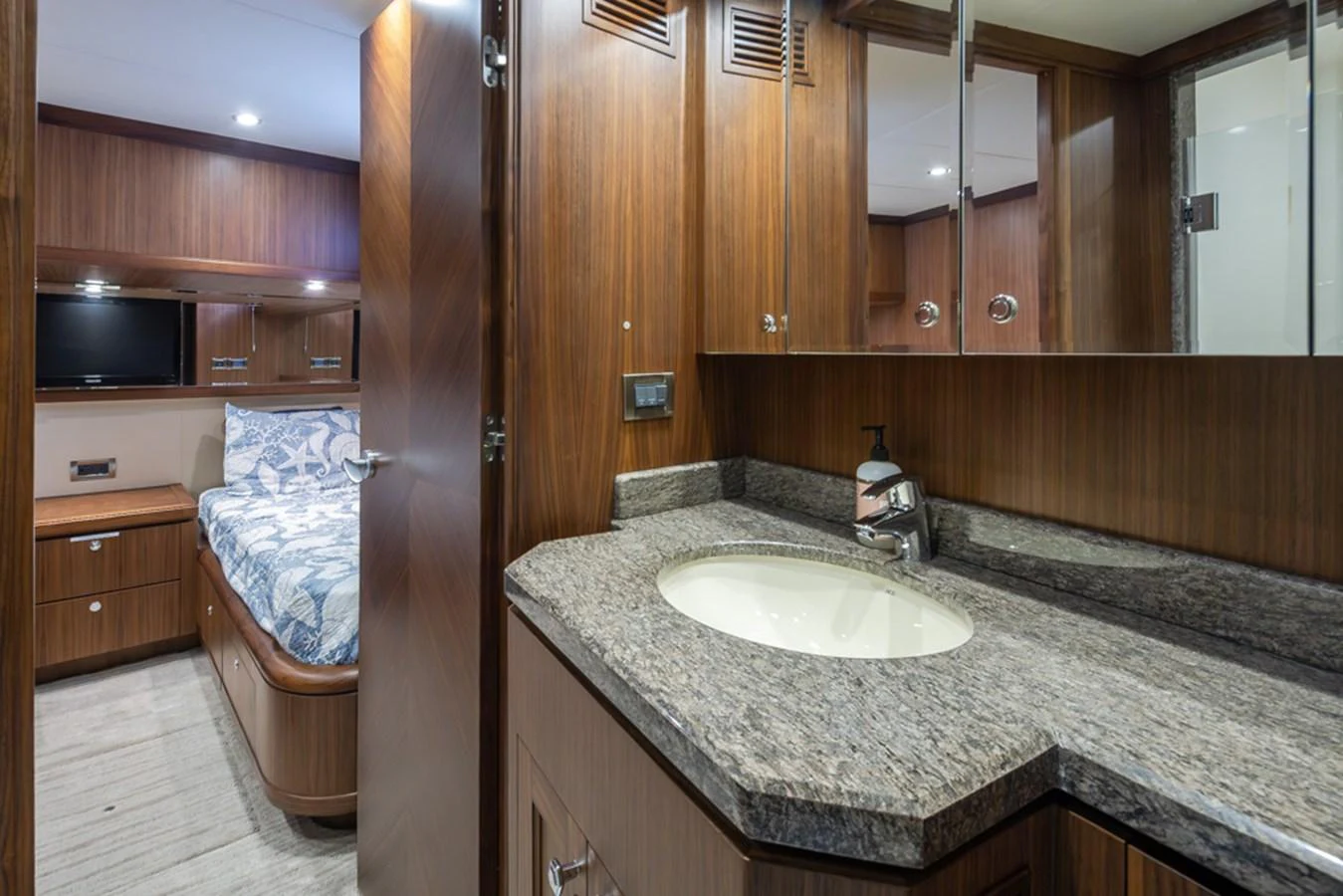 The yacht's bathroom features a sleek design with a granite countertop and wooden cabinetry. aboard RHONDAVOUS Yacht for Sale