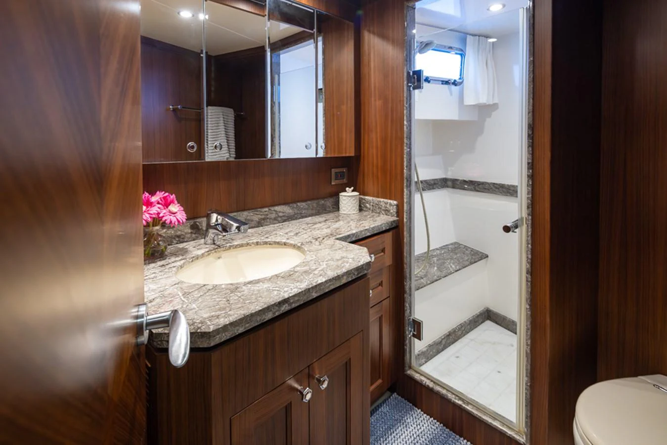 The yacht's bathroom features elegant wood paneling and a spacious shower area. aboard RHONDAVOUS Yacht for Sale