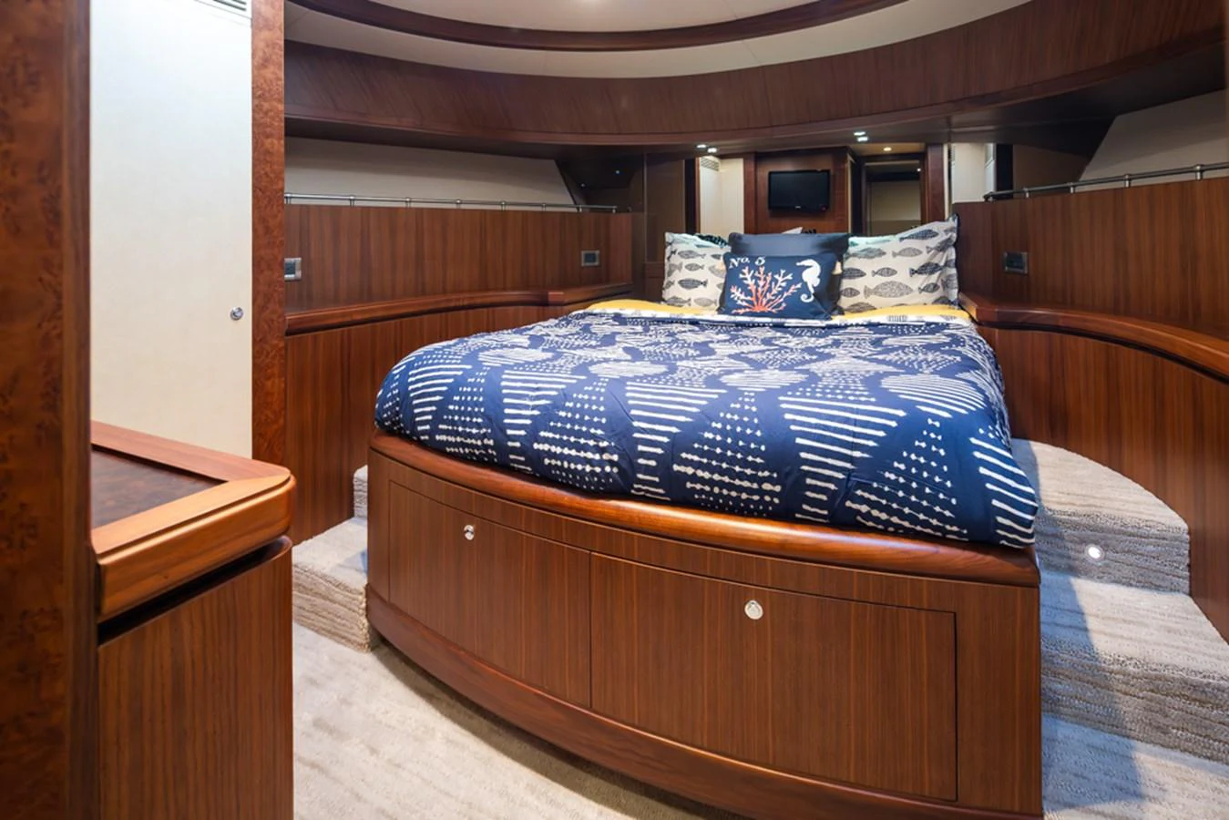 The stateroom features a cozy bed with elegant wooden finishes and modern lighting. aboard RHONDAVOUS Yacht for Sale