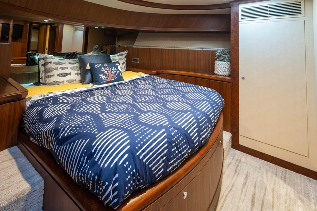 The stateroom features a cozy bed with stylish bedding and warm wooden accents. aboard RHONDAVOUS Yacht for Sale