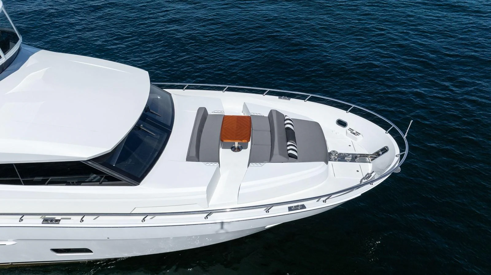 The foredeck features comfortable sun pads and a stylish table for relaxation. aboard SUB-PAR Yacht for Sale