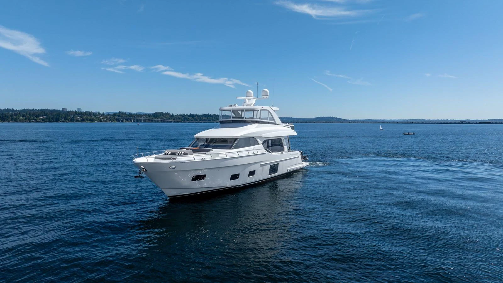 A sleek yacht cruises gracefully on calm blue waters under a clear sky. aboard SUB-PAR Yacht for Sale