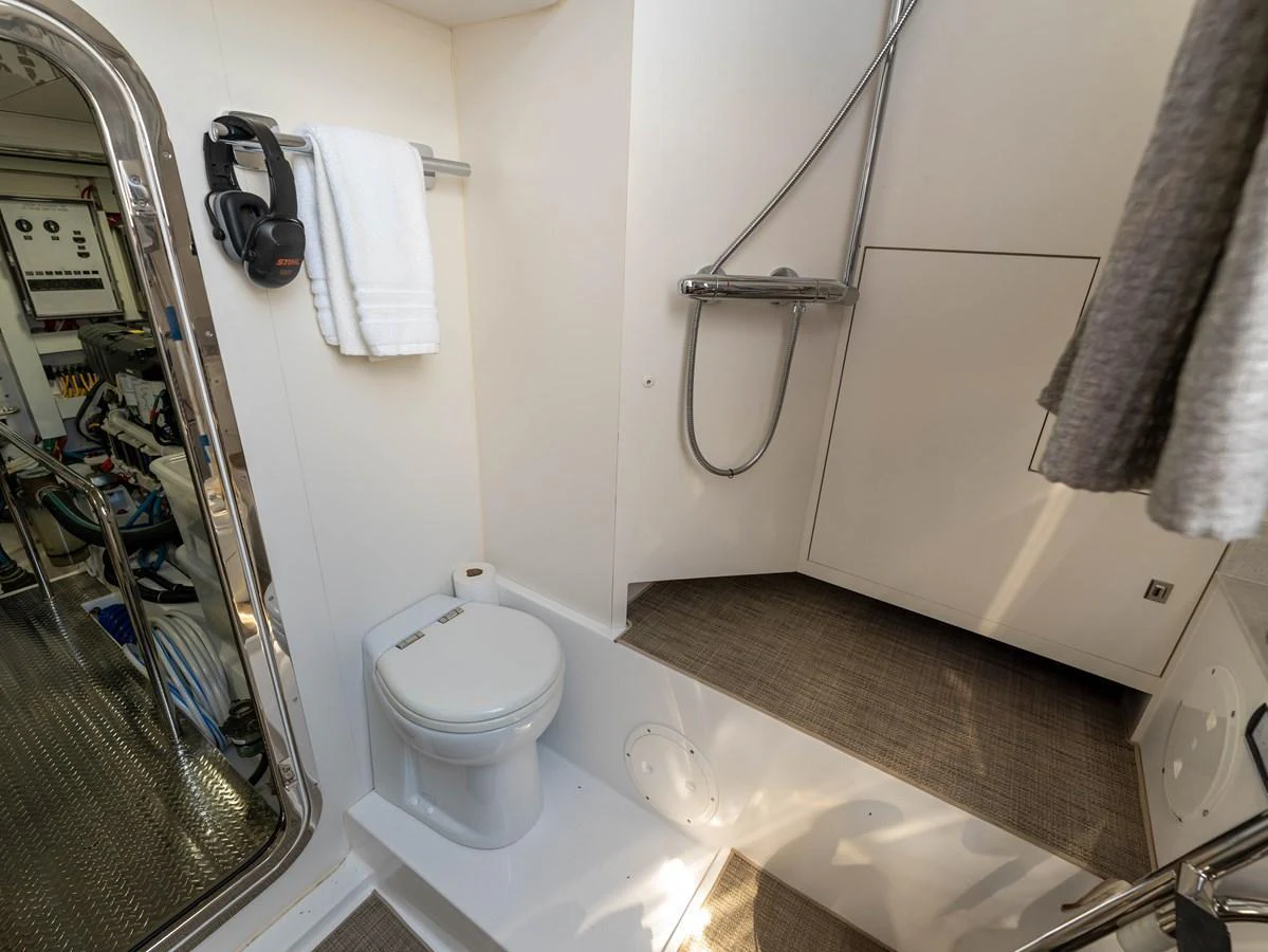 A modern yacht bathroom featuring a toilet, shower, and towel rack. aboard SUB-PAR Yacht for Sale