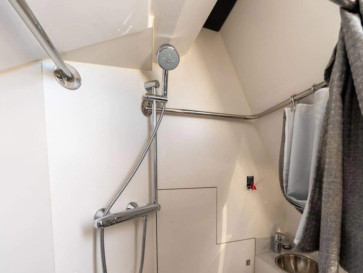 A sleek and modern yacht bathroom with a stainless steel shower and sink. aboard SUB-PAR Yacht for Sale