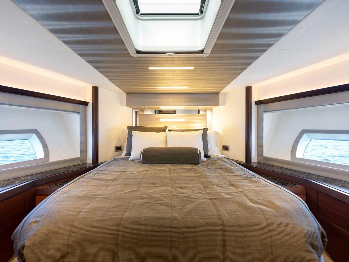 A luxurious stateroom with a large bed and ample natural light from side windows and a skylight. aboard SUB-PAR Yacht for Sale
