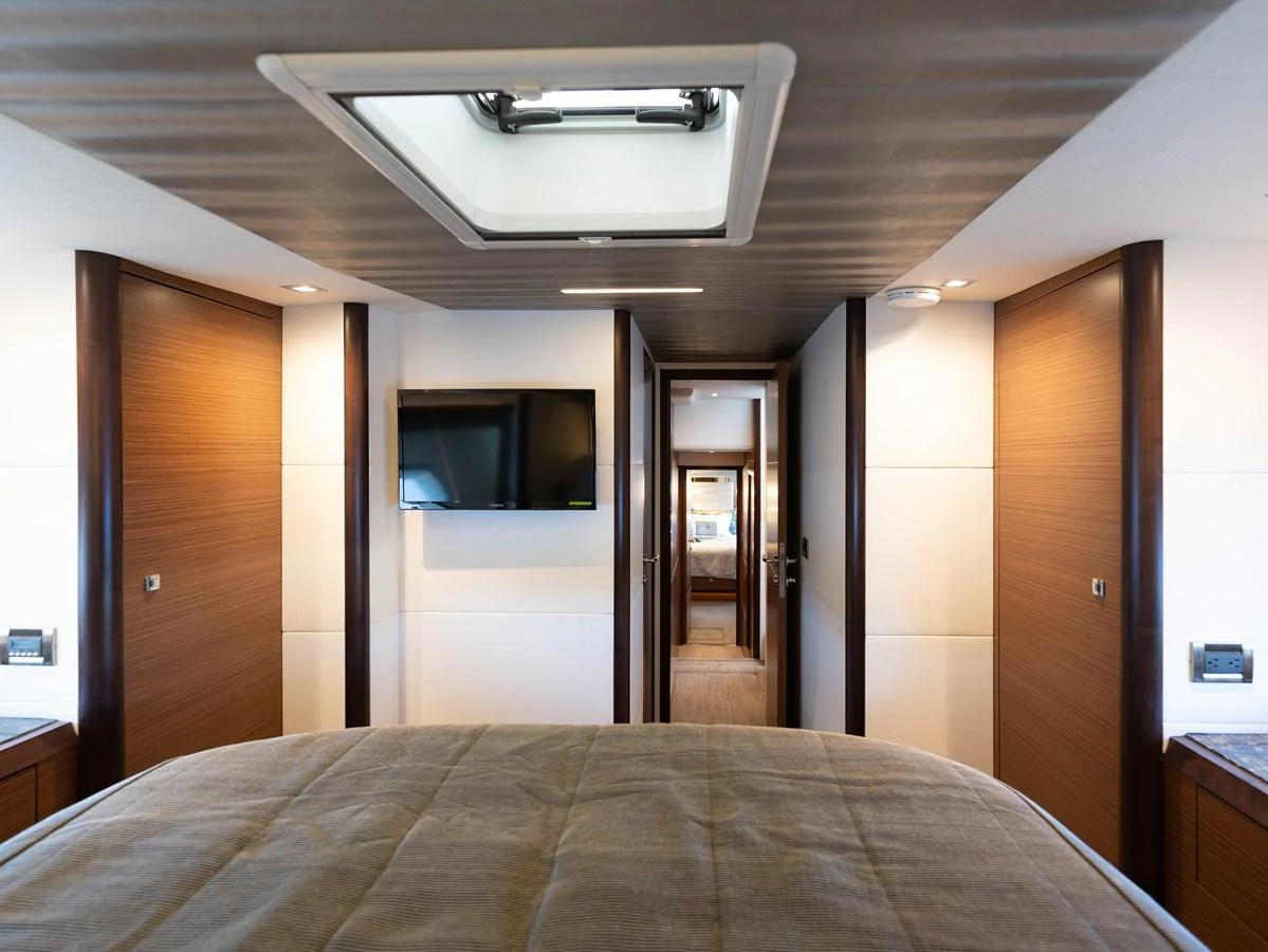 The stateroom features a comfortable bed, modern lighting, and a wall-mounted television. aboard SUB-PAR Yacht for Sale