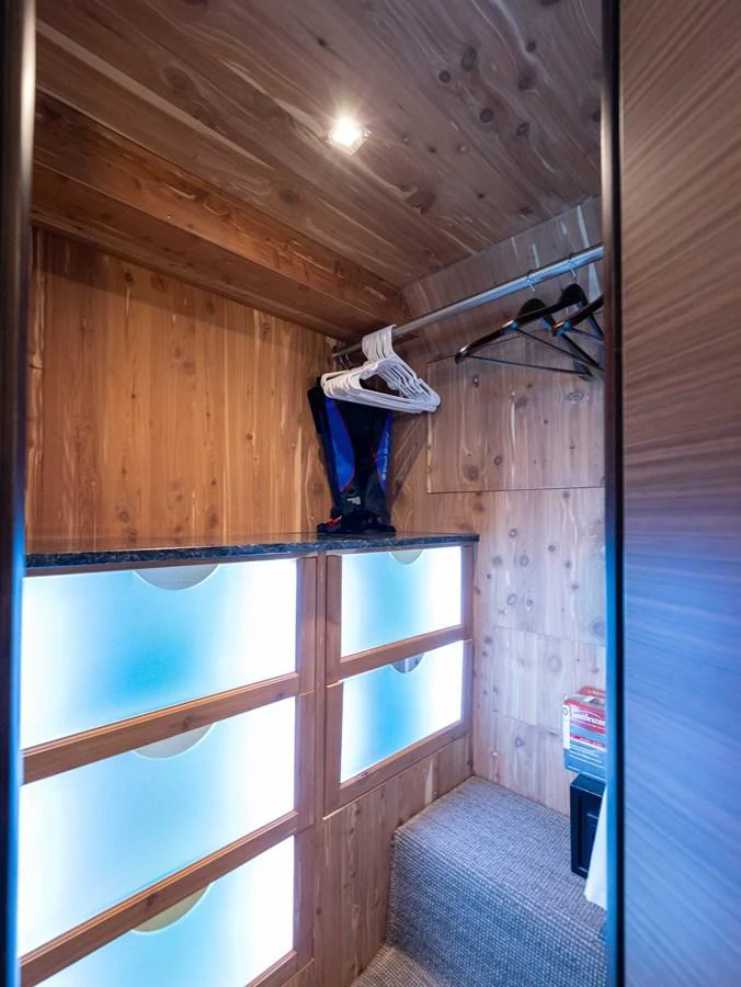 A well-organized yacht closet with wooden paneling and illuminated drawers. aboard SUB-PAR Yacht for Sale