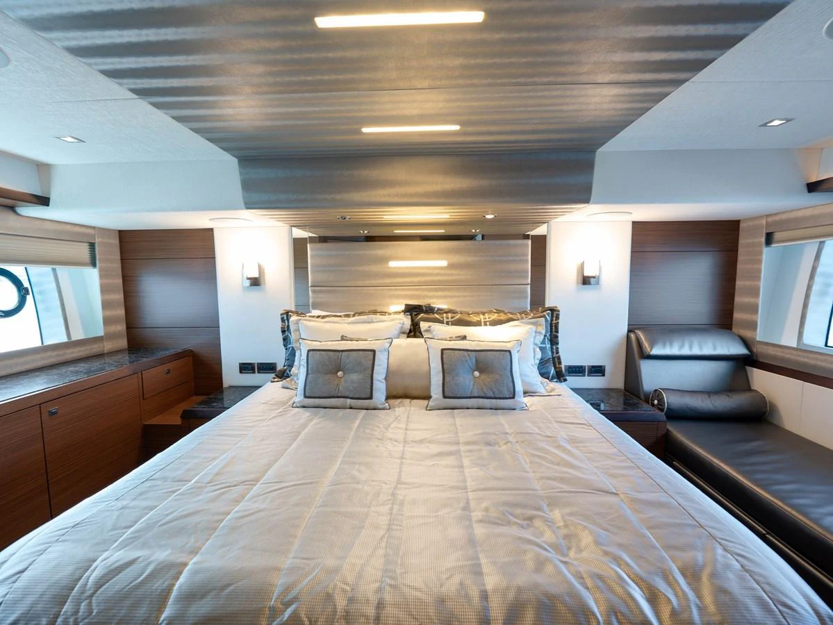 The master stateroom features a luxurious bed with elegant bedding and ample natural light. aboard SUB-PAR Yacht for Sale