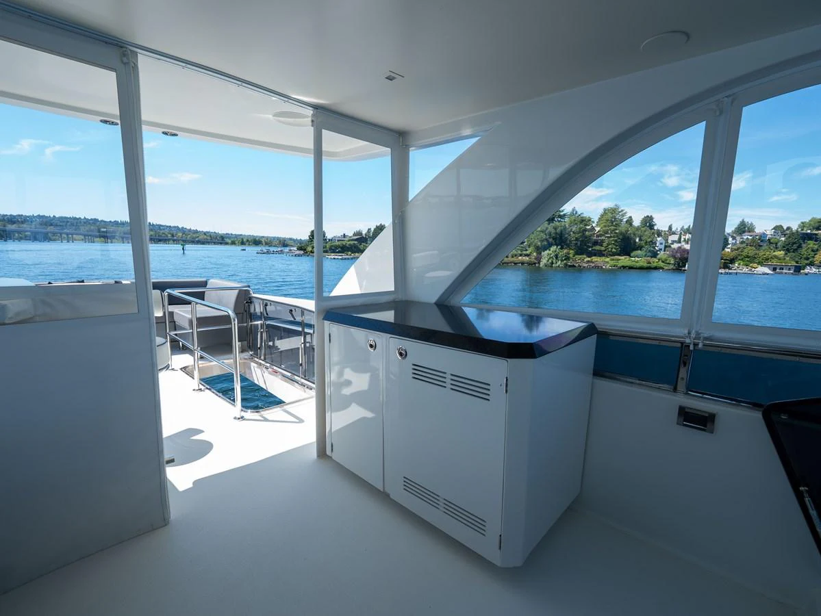 The yacht's aft deck offers a serene view of the water, complemented by a sleek countertop and ample seating. aboard SUB-PAR Yacht for Sale