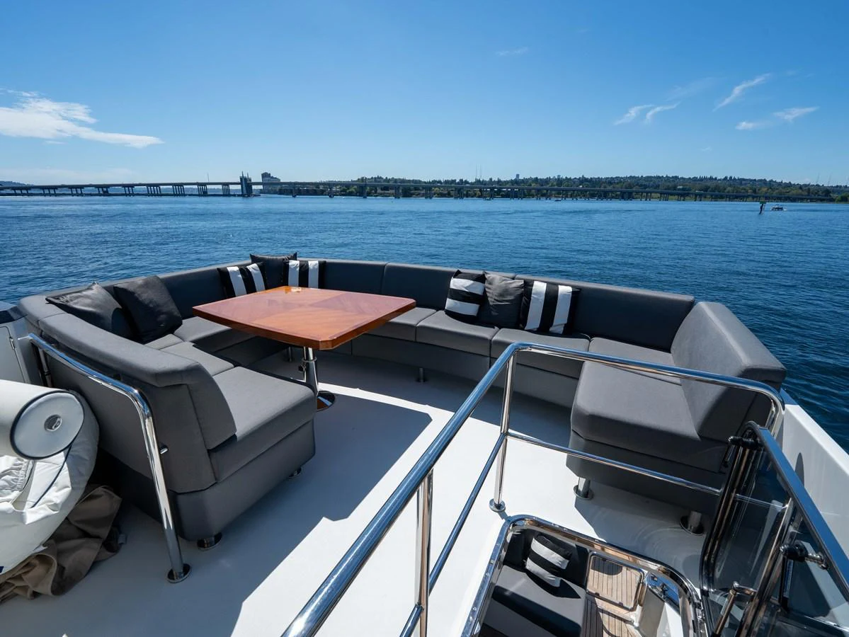 The sundeck features a spacious seating area with a central table, perfect for outdoor relaxation and dining. aboard SUB-PAR Yacht for Sale