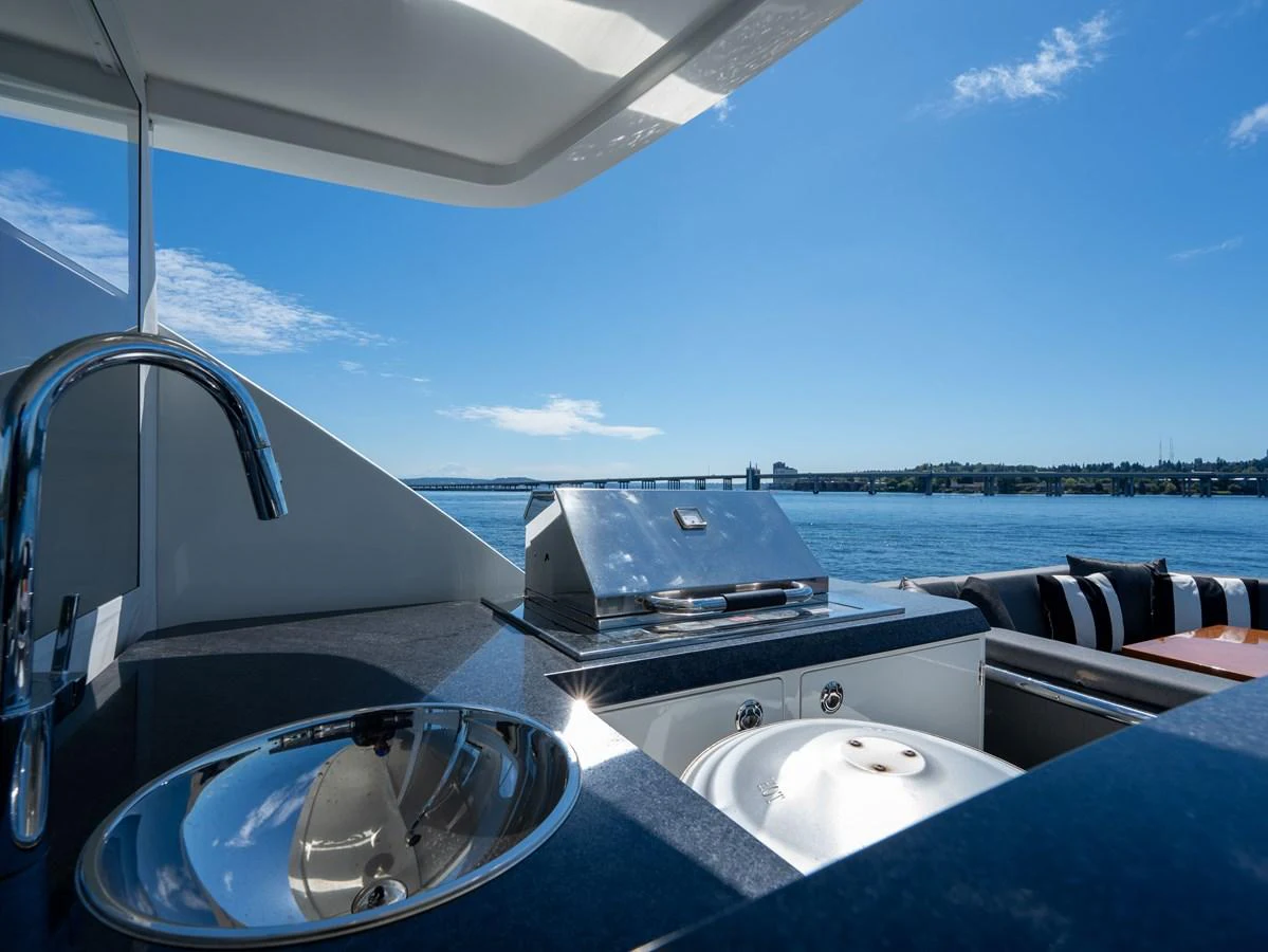 This outdoor galley offers a sleek and functional space for alfresco dining with stunning water views. aboard SUB-PAR Yacht for Sale