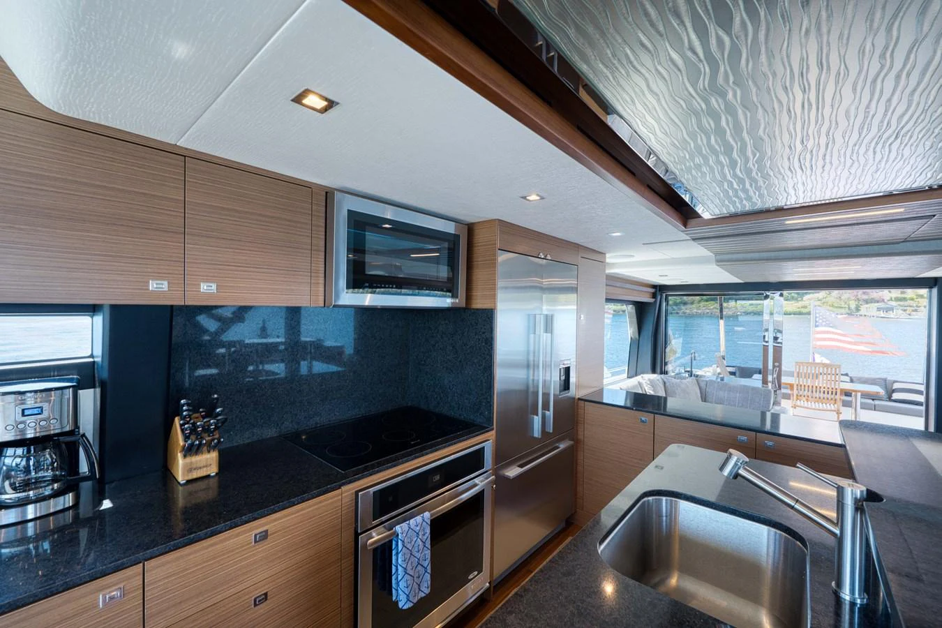 A modern galley with stainless steel appliances and a view of the water. aboard SUB-PAR Yacht for Sale
