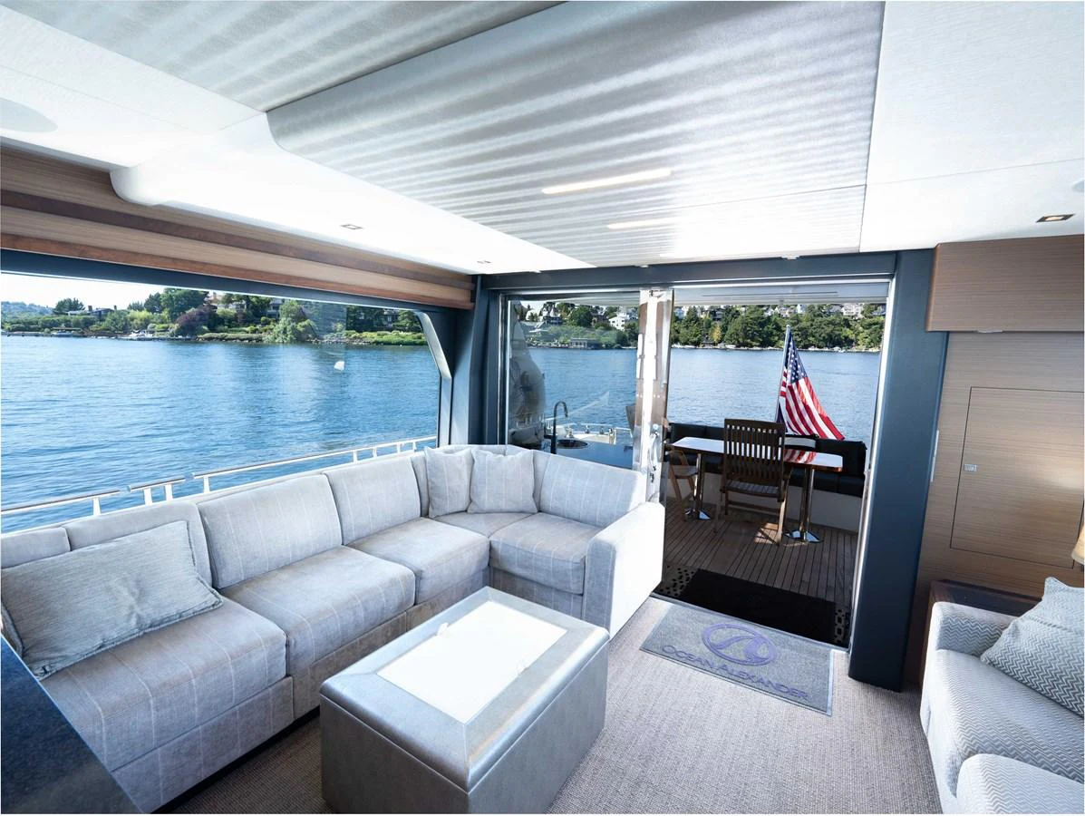 The salon offers a spacious and comfortable seating area with a view of the water through large sliding glass doors. aboard SUB-PAR Yacht for Sale
