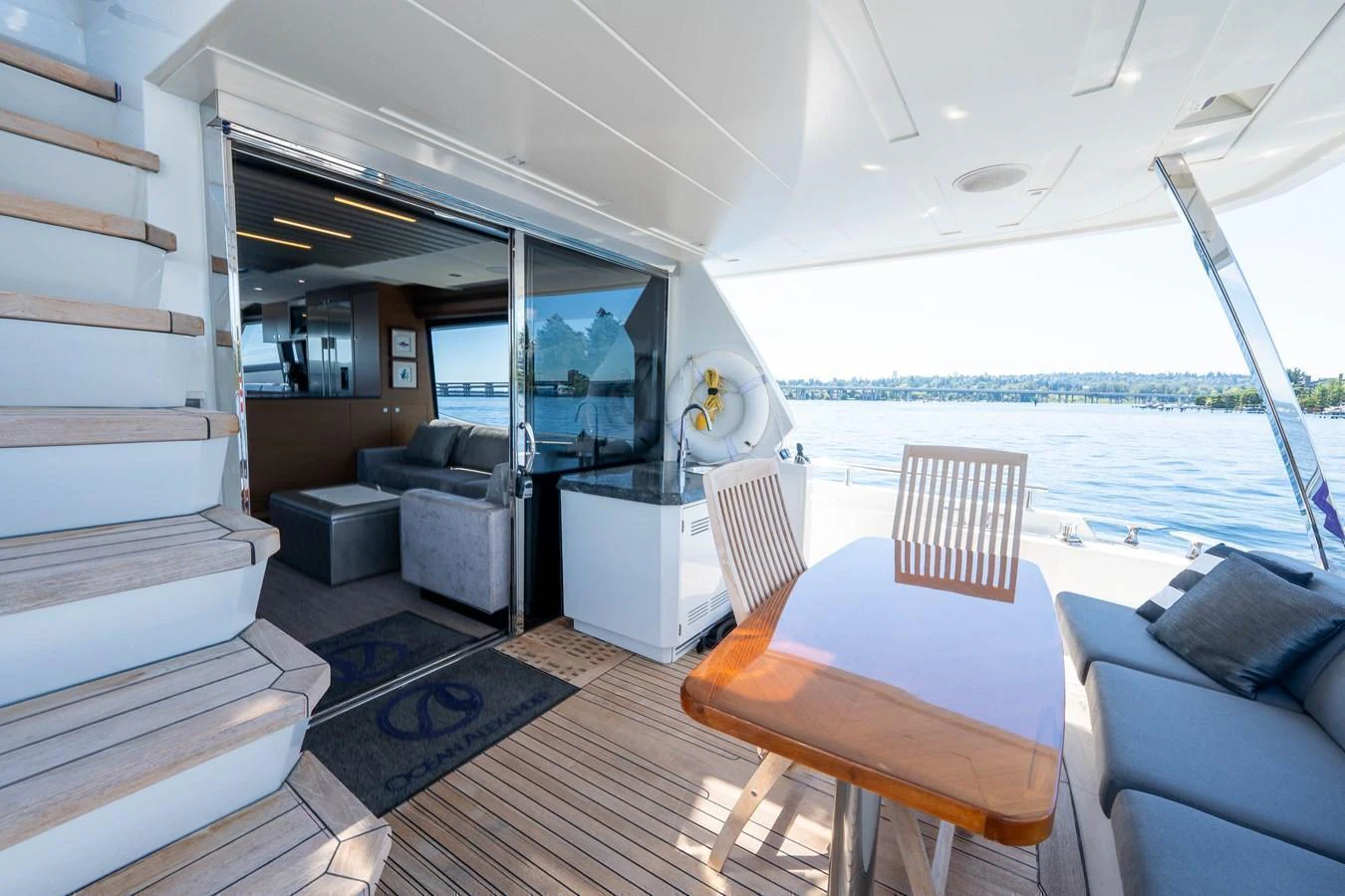 The aft deck features a comfortable seating area with a table, seamlessly connecting to the interior lounge. aboard SUB-PAR Yacht for Sale