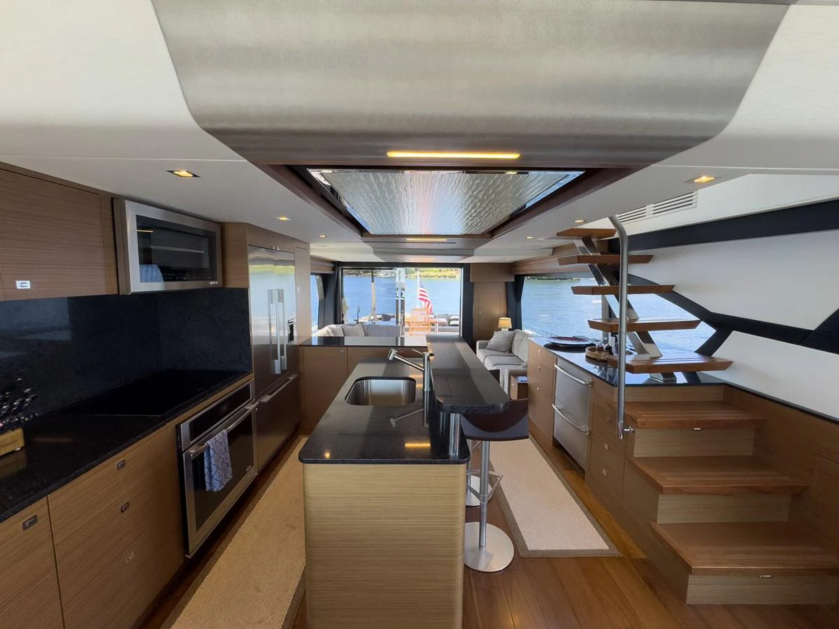 The galley features modern appliances, sleek countertops, and a stylish staircase leading to the upper deck. aboard SUB-PAR Yacht for Sale
